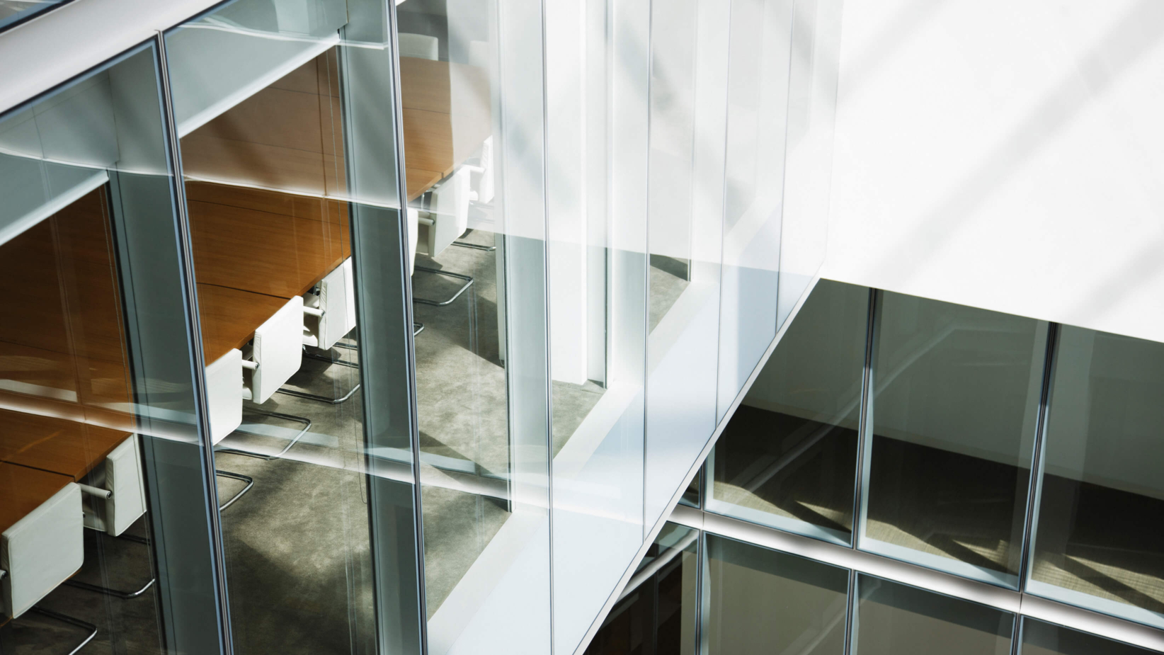 The banner image shows A modern office space with sleek glass walls and a minimalist design reflects professionalism and transparency. The conference room, featuring a long wooden table and white chairs, is bathed in natural light, creating an atmosphere of collaboration and strategic decision-making. The architecture embodies innovation, openness, and corporate excellence in a contemporary workplace.